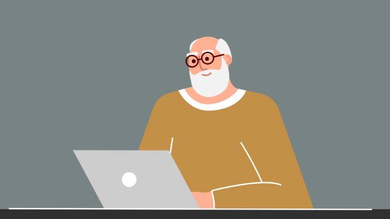 Senior man studies and teaches modern technologies using a laptop. A positively smiling grandfather sits at a computer