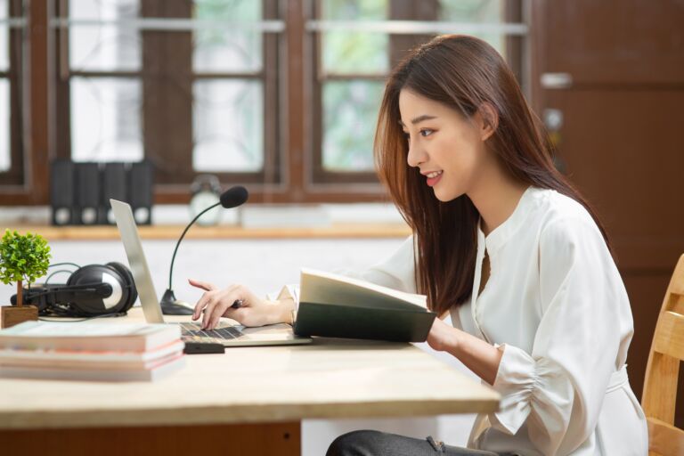 Adult asian woman studying on a laptop